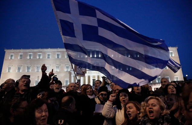 Protesters wave Greek flags in front of Greece’s Parliament to support the new Syriza-led government in its eurozone bailout negotiations last month. (AP / Petros Giannakouris)